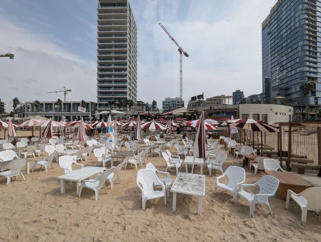 Beach bar seating with red and white umbrellas at Banana Beach