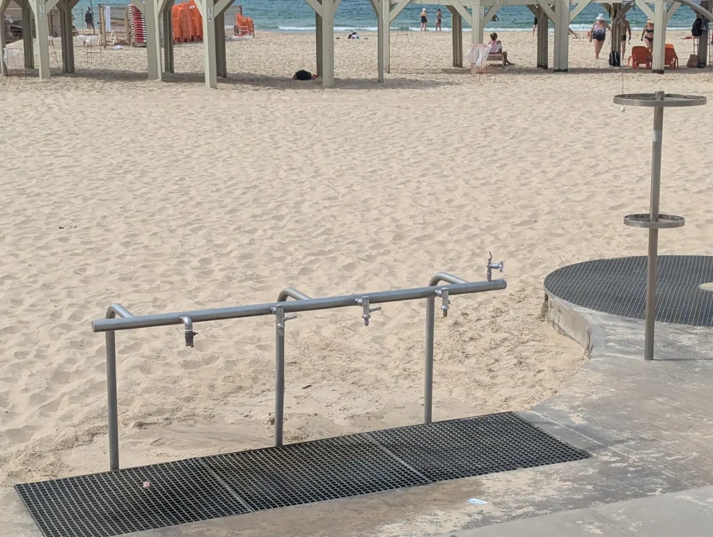 Foot shower bar over a metal grate by the promenade