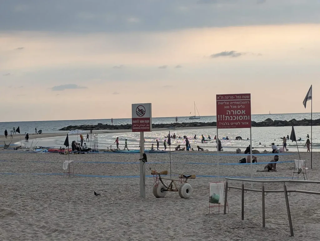Gordon Beach with warning signs and the sea at sunset