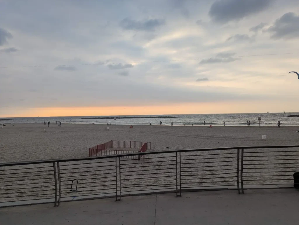 Curved promenade railing above the open sand of Trumpeldor Beach, Tel Aviv