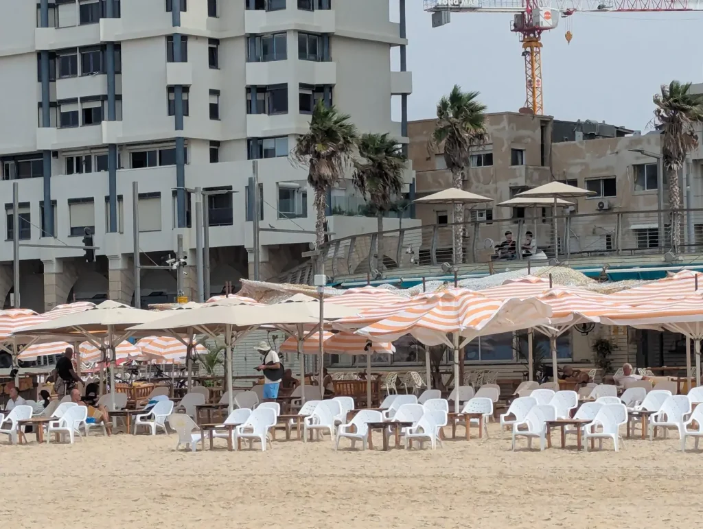 Beach restaurant with striped umbrellas at Jerusalem Beach