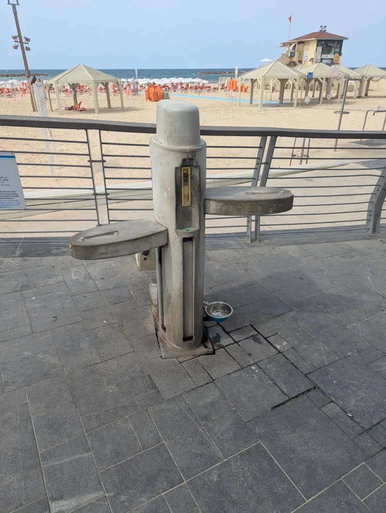 Drinking fountain on the promenade with the beach behind