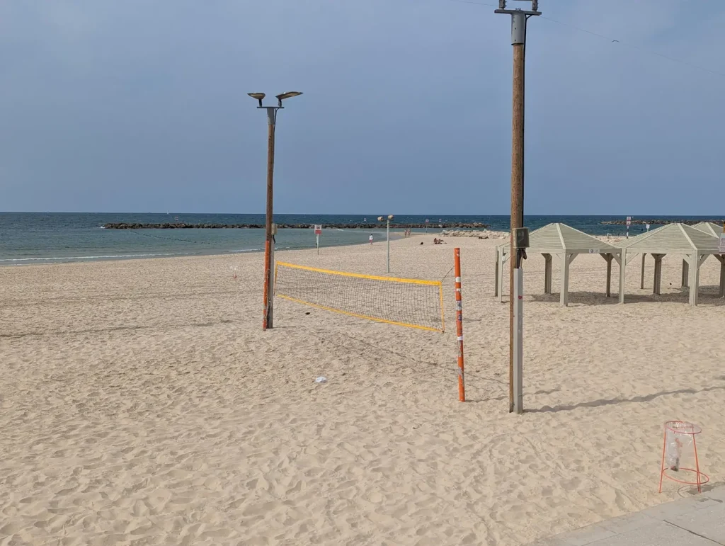 Volleyball net between shade huts on the sand