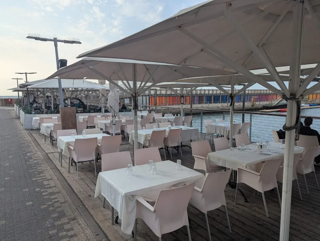 White Pergola outdoor terrace with white tablecloths by the water