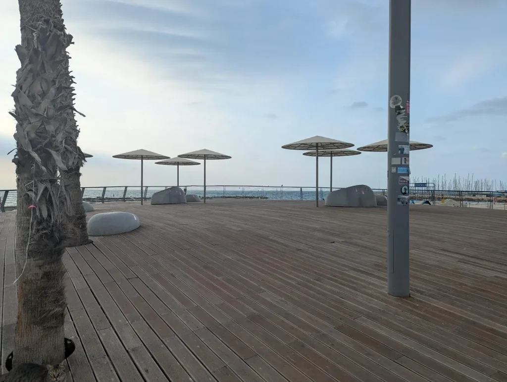 Wooden promenade deck with umbrella shades and sea view